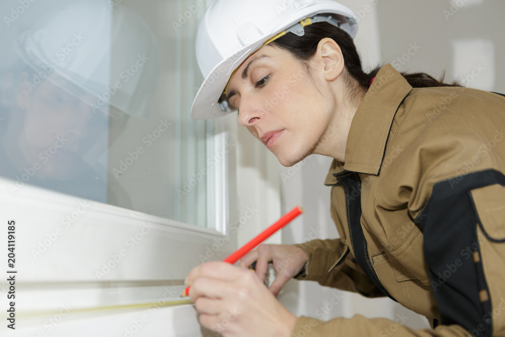 Woman measuring window frame