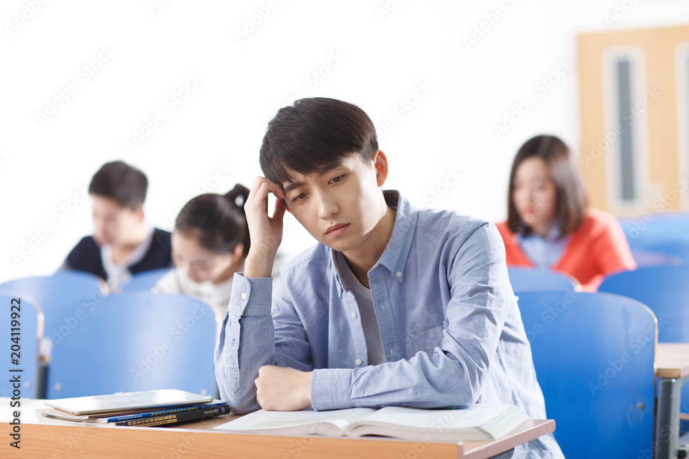 Thoughtful college student sitting in a classroom Thoughtful college student sitting in a classroom