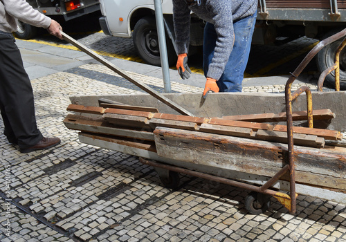 Retirada a mano de viejos tablones de madera durante la reforma de un antiguo local comercial photo