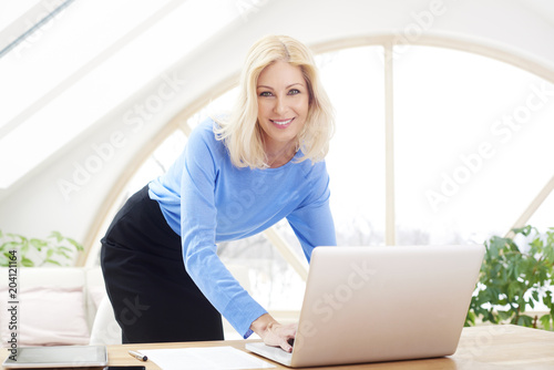 Businesswoman working on laptop from home. Home office.