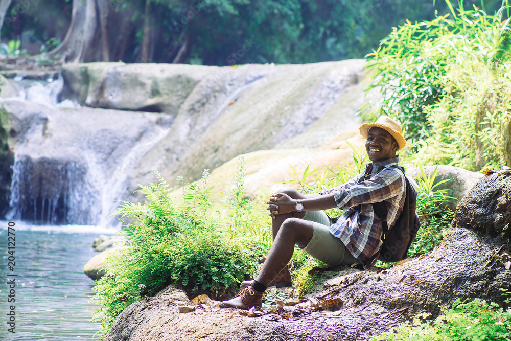 African Man Traveler  relaxing freedom at waterfall