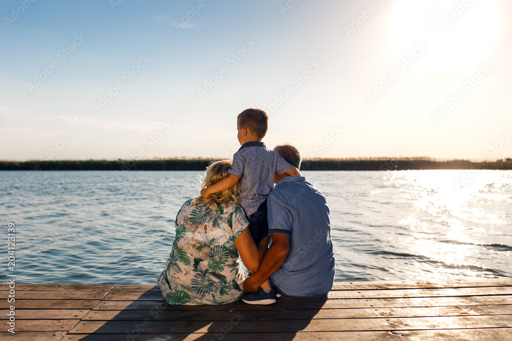 Grandparents with grandson enjoying time together by the lake.