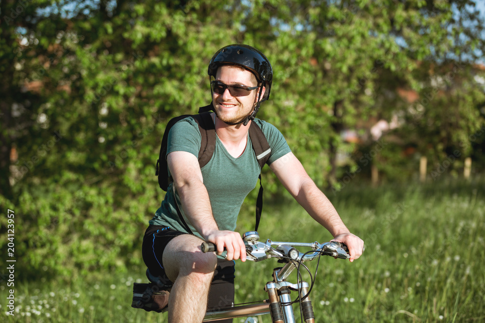 Obraz premium Young man sitting on his bike in nature