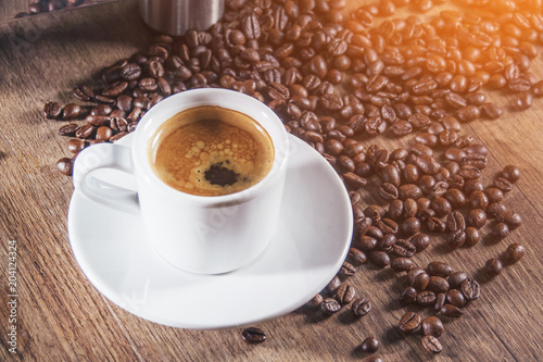 White Cup of Espresso on wooden table. Top view.