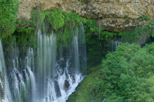 Waterfall seeping out of seems in bedrock, Burney Falls, California  photo