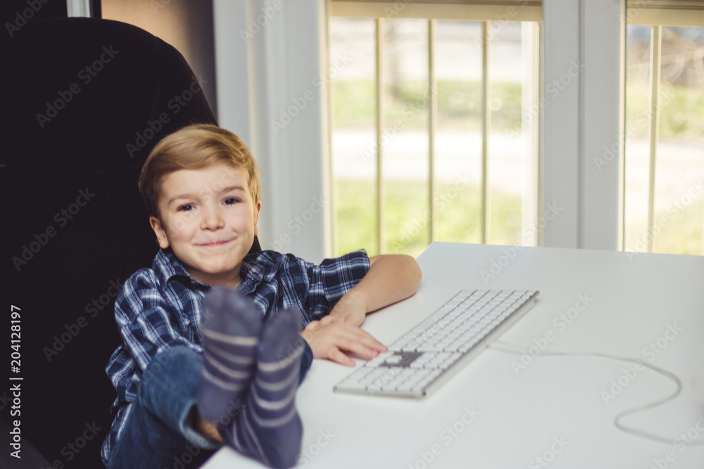 Happy kid enjoying in the office with feet up on the table. Happy kid enjoying in the office with feet up on the table.