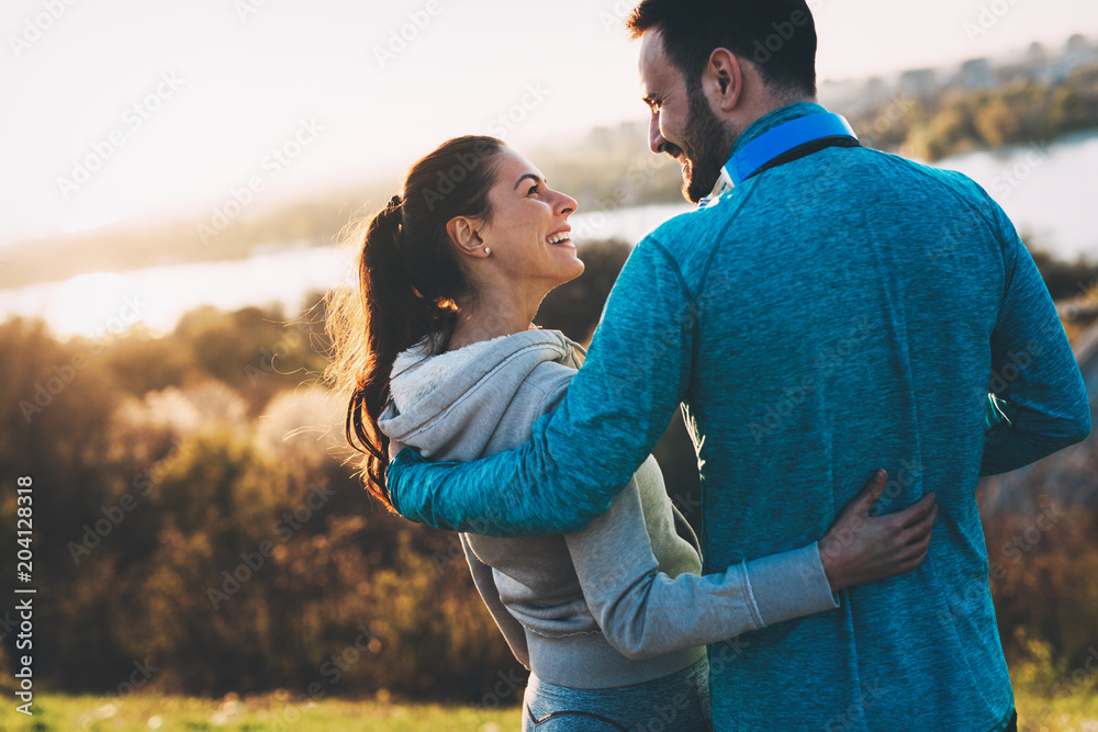 Happy young sporty couple sharing romantic moments Happy young sporty couple sharing romantic moments