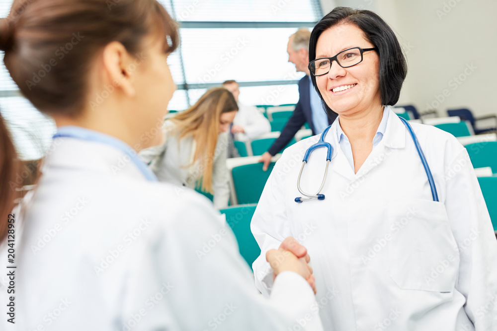 Ärztin begrüßt junge Kollegin mit Handschlag