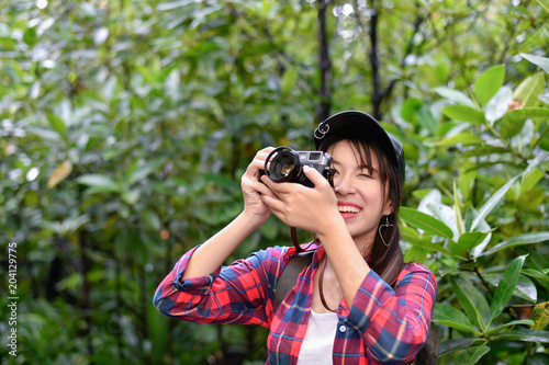 Travel concept. Asian girls are traveling in the woods.  Beautiful women are taking photos in the forest. © S photographer