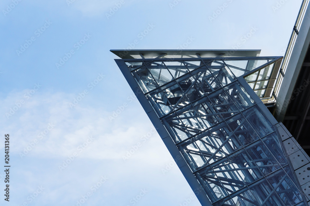 The glass elevator shaft with metal partitions on the street adjoins the bridge.