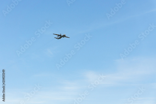 In a clear blue sky, a small plane with screw engines.