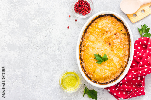 Cheese garlic potato gratin in baking dish on concrete background.Top view, space for text.