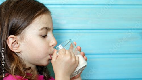 Cute little girl enjoys the taste of fresh milk