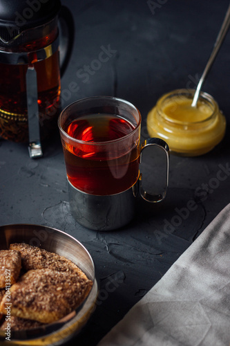 Glass cup of tea with biscuits and honey photo