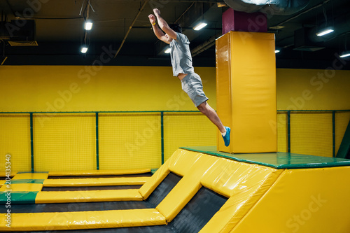 trampoline jumper performs complex acrobatic exercises and somersault on the trampoline. photo