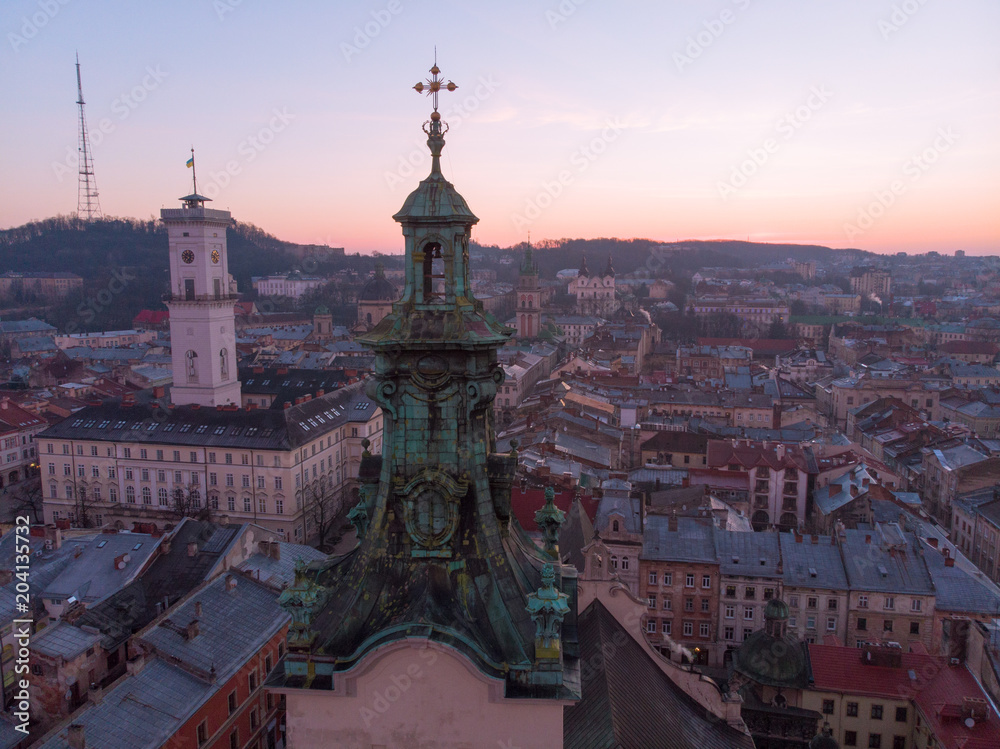 old church tower with sunrise on background. european cityscape aerial view