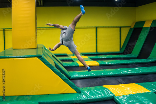 trampoline jumper performs complex acrobatic exercises and somersault on the trampoline. photo