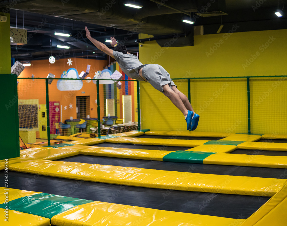 trampoline jumper performs complex acrobatic exercises and somersault on  the trampoline. Stock Photo | Adobe Stock