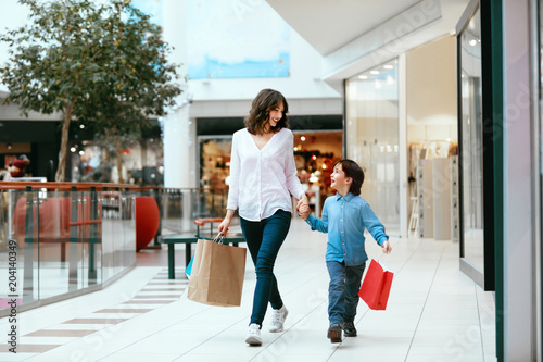 Shopping. Young Mother And Kid With Bags In Mall