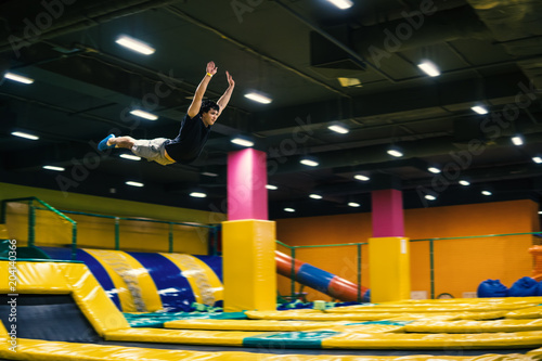 trampoline jumper performs complex acrobatic exercises and somersault on the trampoline.