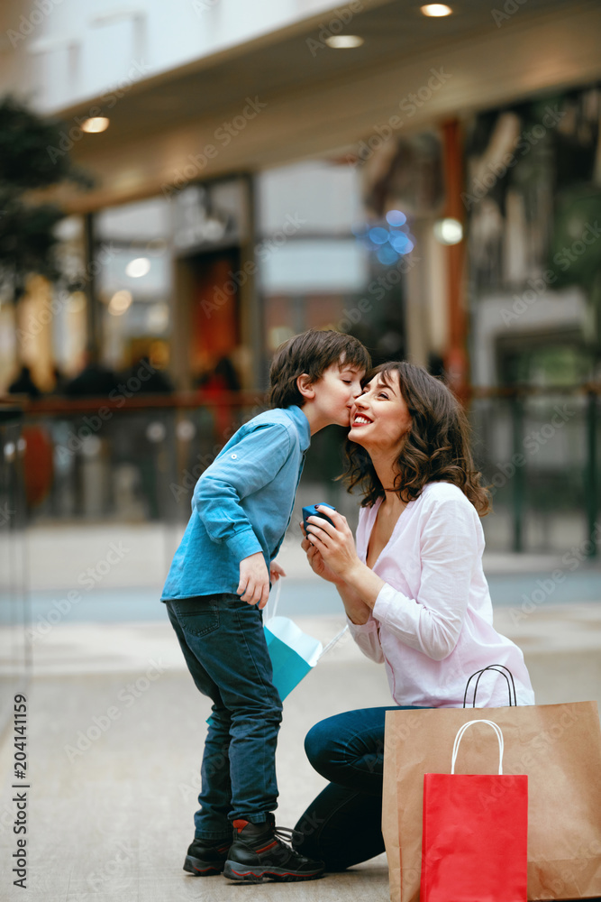 Fototapeta premium Shopping Centre. Child Giving Presents To Mother