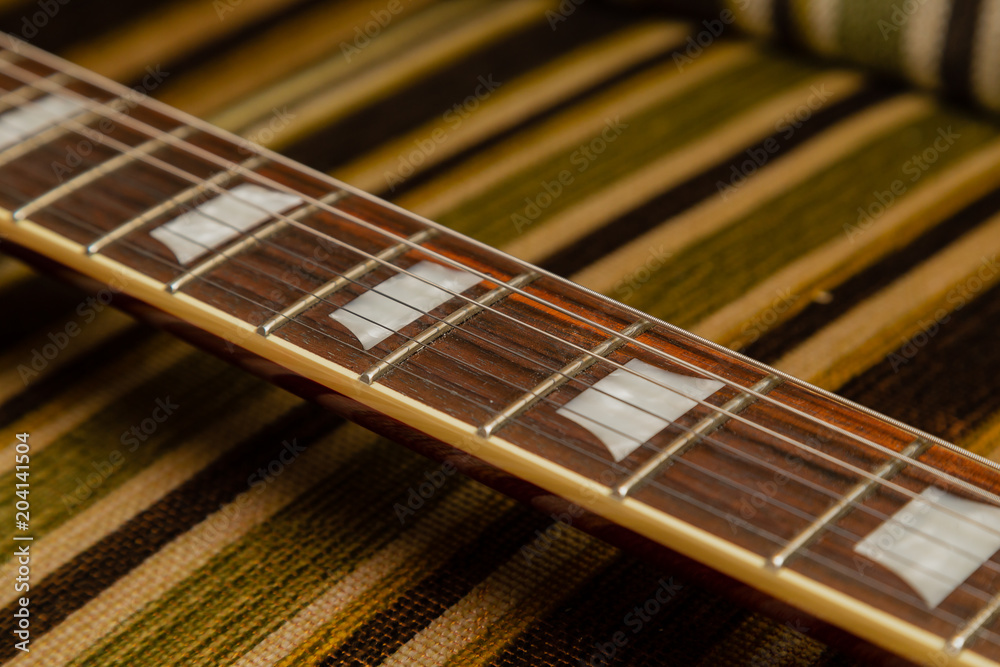 Electric guitar body and neck detail on wooden background vintage look Electric guitar body and neck detail on wooden background vintage look