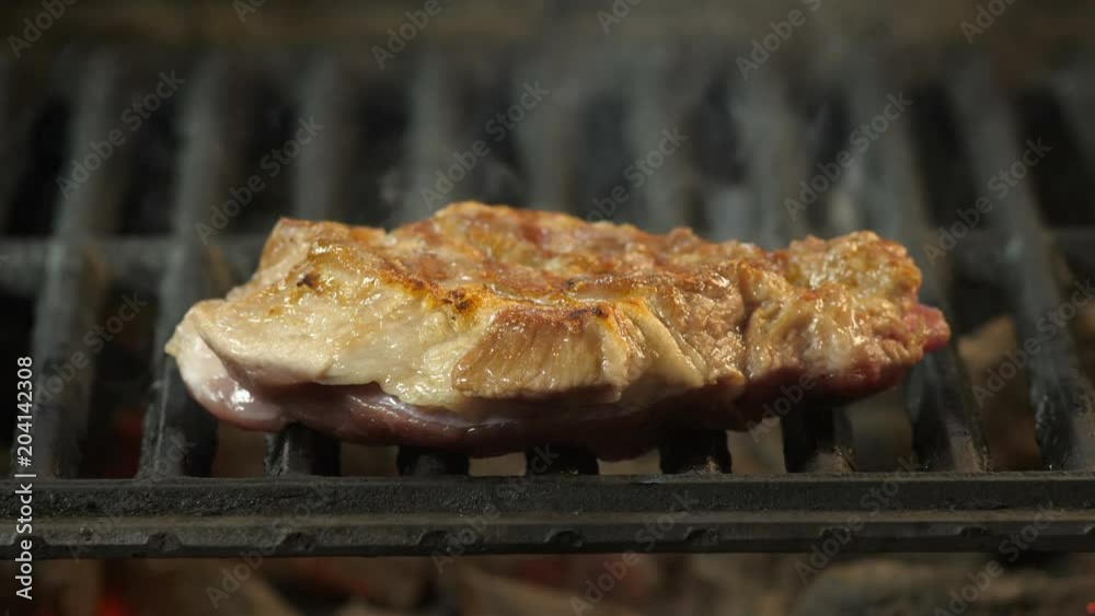 Grilled steak close-up in the background of smoke, juicy large piece of beef or veal grilled, restaurant dish, delicacy, close-up video Grilled steak close-up in the background of smoke, juicy large piece of beef or veal grilled, restaurant dish, delicacy, close-up video