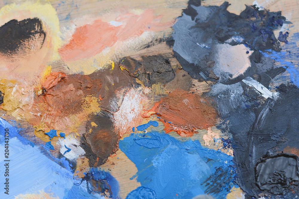 Colorful artist's palette with oil paint strokes.