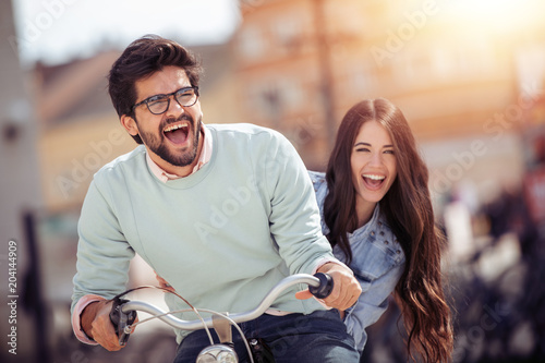 Couple riding on bicycle and having fun