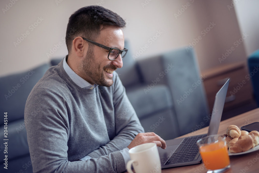 Man sitting on floor while watching laptop at home Man sitting on floor while watching laptop at home
