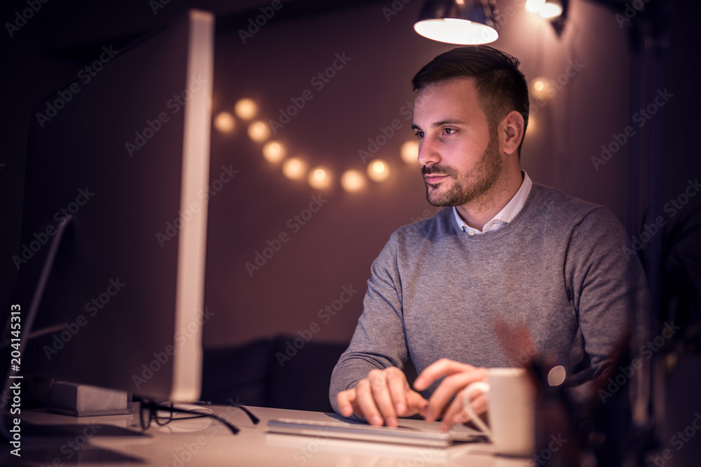 Man working on computer late at night Man working on computer late at night