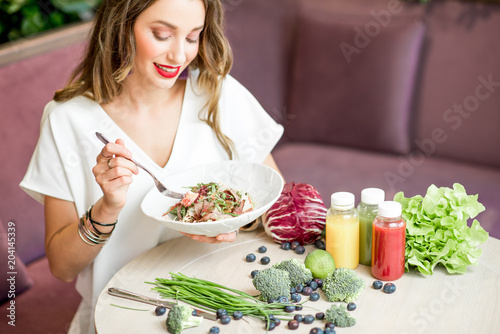 Woman with healthy food and smoothies indoors