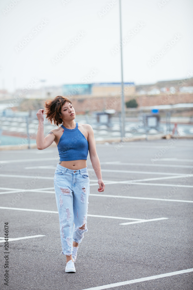 Portrait of hard fashion young Asian girl in a parking in the city. Lifestyle concept Portrait of hard fashion young Asian girl in a parking in the city. Lifestyle concept
