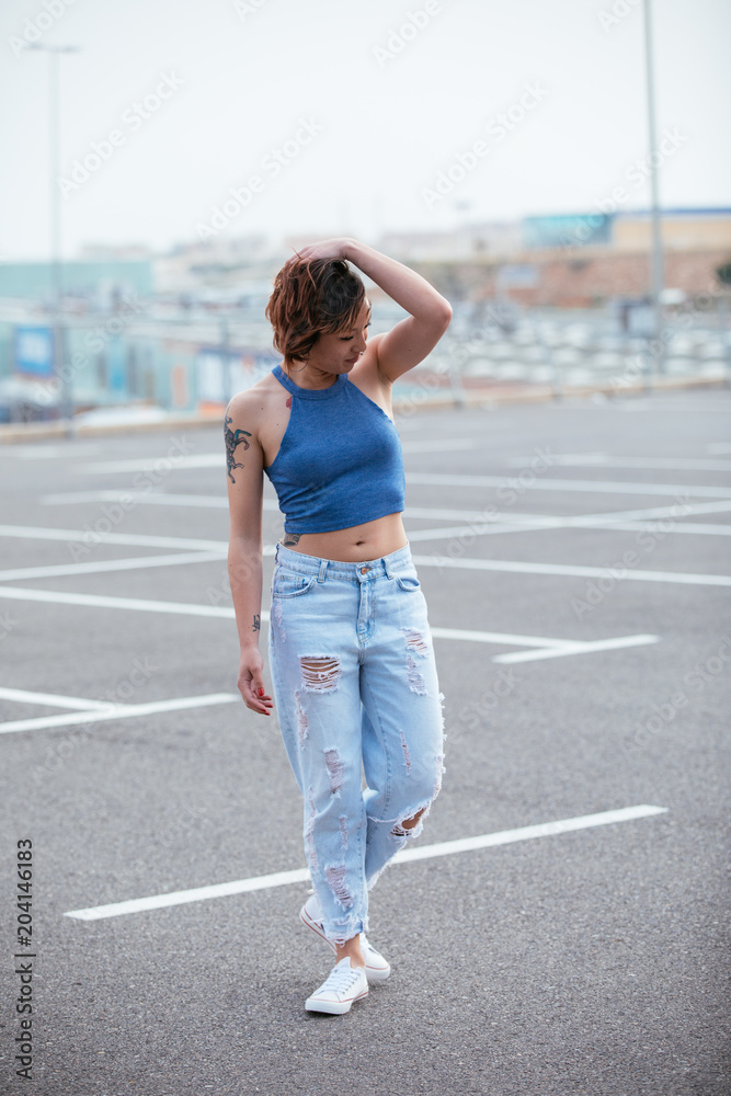 Portrait of hard fashion young Asian girl in a parking in the city. Lifestyle concept Portrait of hard fashion young Asian girl in a parking in the city. Lifestyle concept