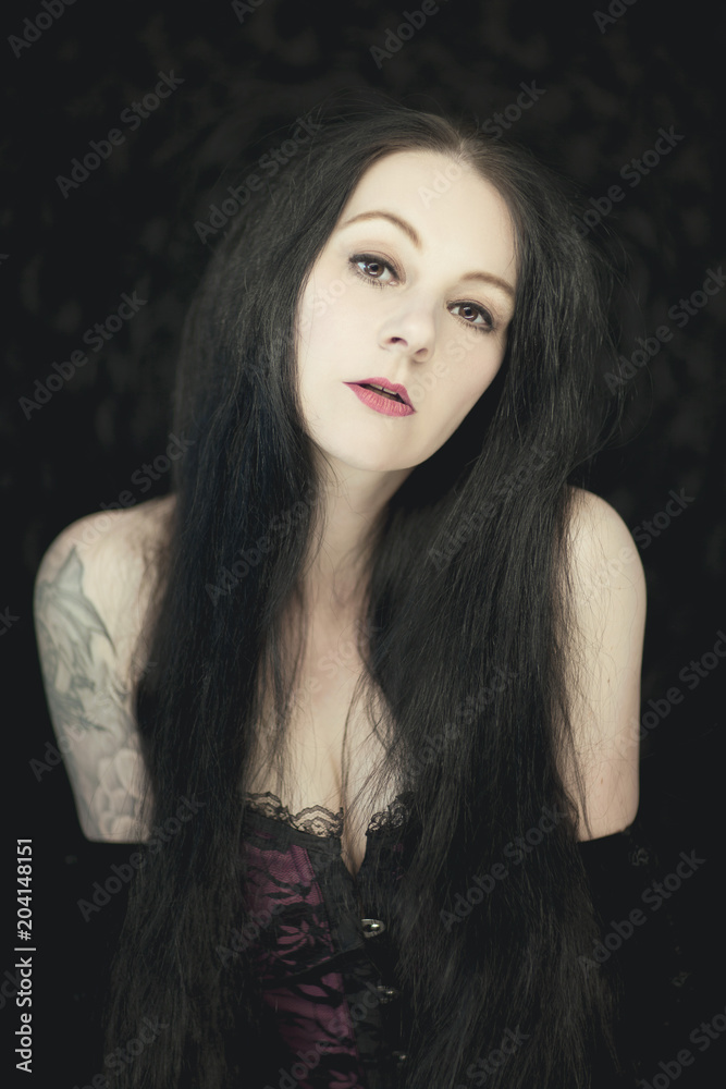 Beautiful german gothic styled woman with shiny long black hair looking into camera Beautiful german gothic styled woman with shiny long black hair looking into camera