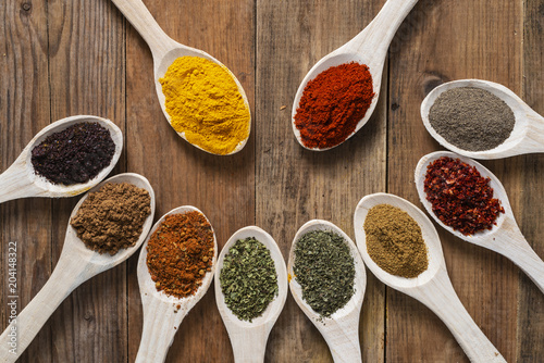 Assorted spices on wooden spoons. Delicious food ingredients.