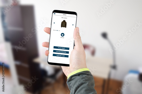 Man holding smartphone with online shopping application on screen