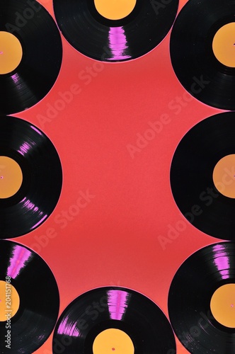 old black vinyl records with blank orange labels on red background as frame