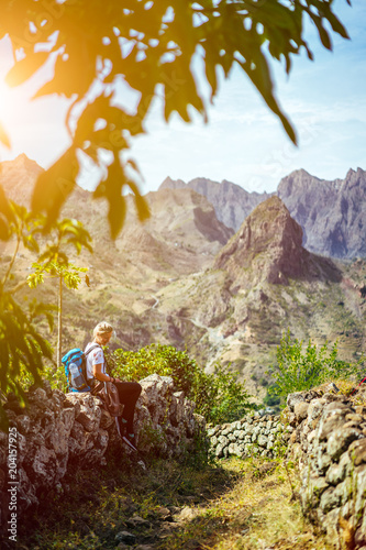 Girl resting on the hiking trail leading through arid rocky terrain towards Coculli village on Santo Antao Cape Verde photo