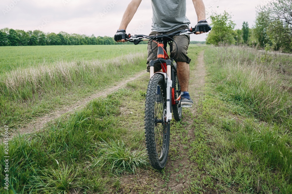 Man riding a bicycle at countryside road. Cyclist in motion. Sports, tourism and activity concept