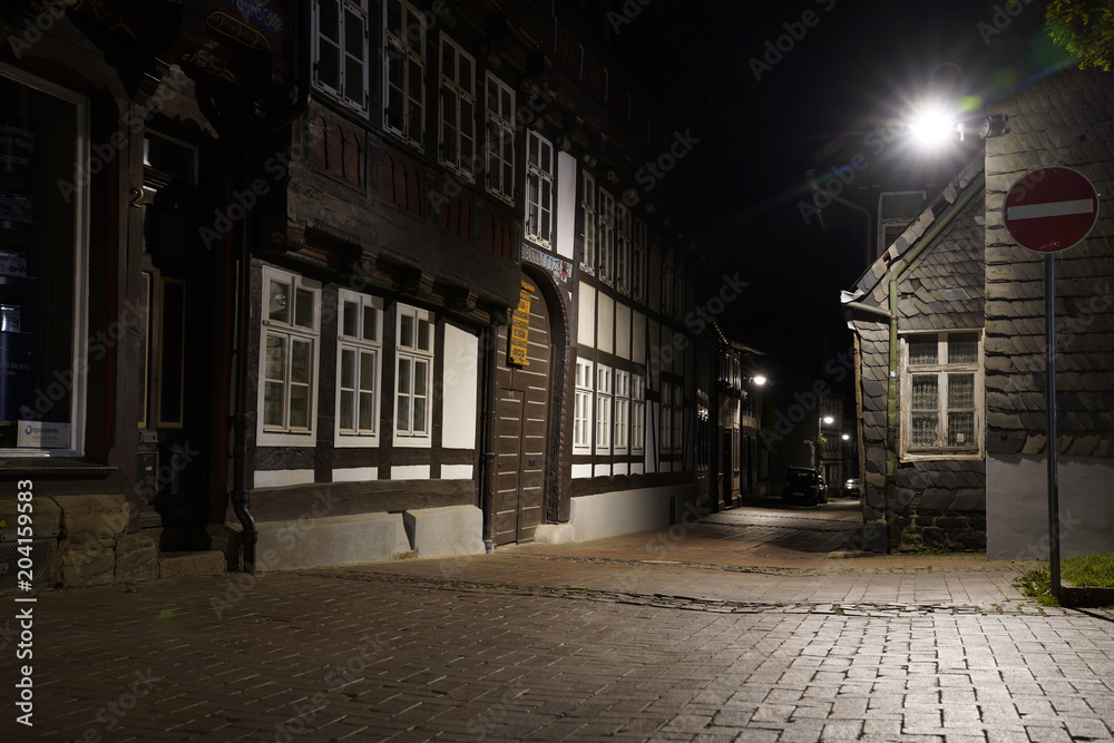  Tiny street with old nordic style houses at night in the town of Goslar, Germany in the Harz region.