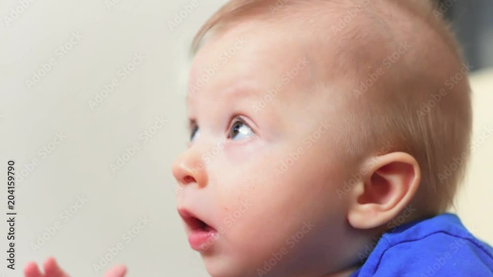 Sweet small baby playing with toys on a white carpet at home. Little baby boy with a toy lying on the floor at home. Sweet small baby playing with toys on a white carpet at home. Little baby boy with a toy lying on the floor at home.