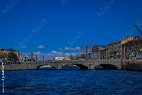 Beautiful outdoor view of Anichkov Bridge on Fontanka river during a sunny day in a blue sky in Saint Petersburg