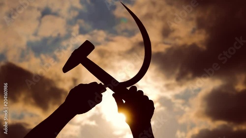 silhouette of a sickle and a hammer against the sky photo