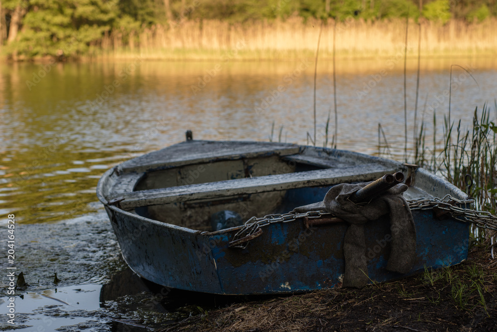 A fishing boat moored to the shore of the lake. Old fishermen's boat prepared for fishing on lakes.