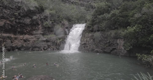 Waimea Falls in Hawaii with tourist swimming in the water photo