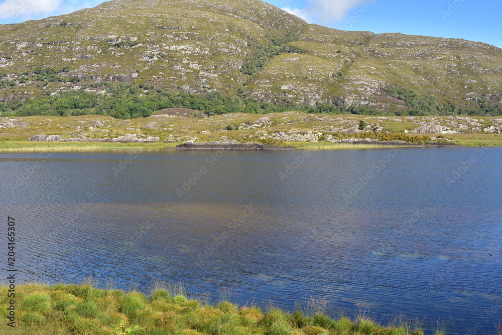 Calm water of lake near Reeks mountain range in Kerry.