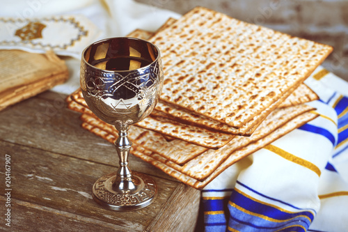 Pesach Passover symbols of great Jewish holiday. Traditional matzoh, matzah or matzo and wine in vintage silver plate and glass.