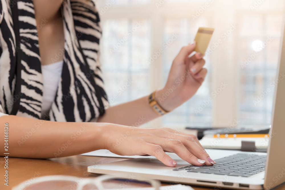 Businesswoman holding credit card and using laptop to shopping online Businesswoman holding credit card and using laptop to shopping online