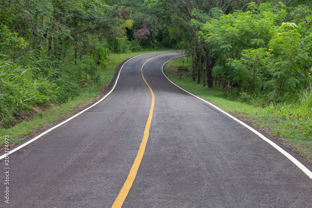 Curve way of asphalt road through the tropical forest in northern Thailand.